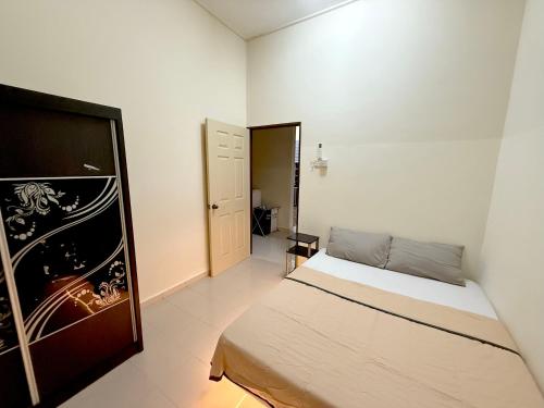 ein kleines Schlafzimmer mit einem Bett und einer Tür in der Unterkunft Misty Haven Homestay - Bungalow in Kuala Terengganu