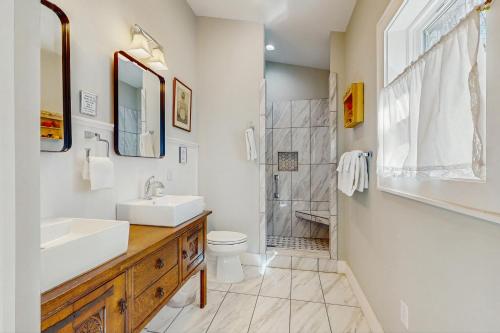 ein Badezimmer mit Waschbecken, Toilette und Dusche in der Unterkunft Bibi's Creek Retreat in Boone