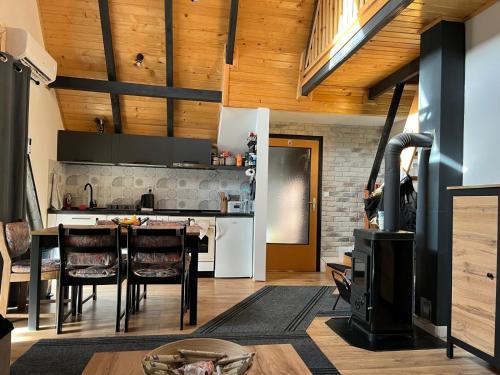 a kitchen with a stove and a table with chairs at Vikendica A&J in Blidinje