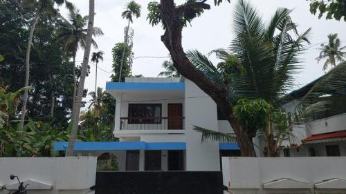 un edificio con una palmera delante en A Wonderful stay, en Kappil