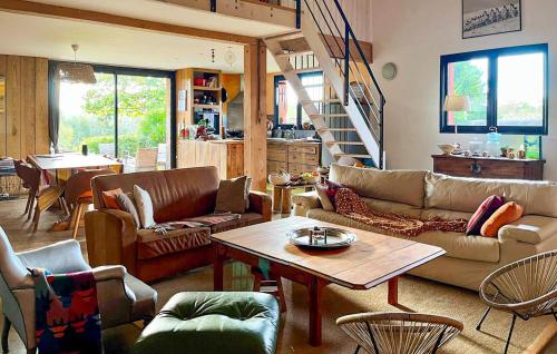 a living room with couches and a table at Superbe Maison Avec Piscine in Mombrier