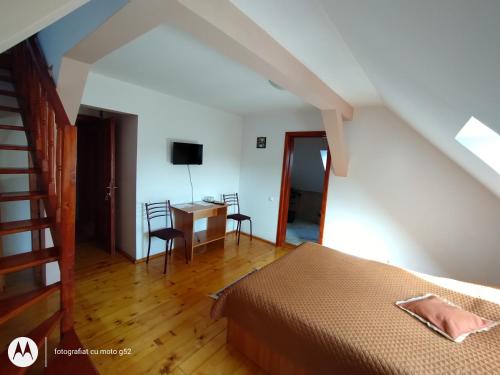 a bedroom with a bed and a desk with two chairs at Casa Pleșca in Sibiu