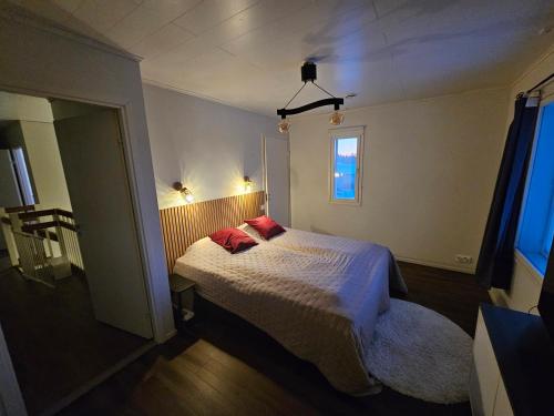 une chambre avec un lit avec deux oreillers rouges dans l'établissement Frozen Villa Lapland, à Rovaniemi