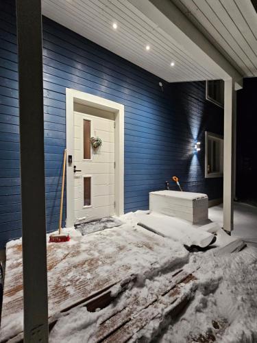 une porte d'entrée d'une maison avec de la neige autour dans l'établissement Frozen Villa Lapland, à Rovaniemi