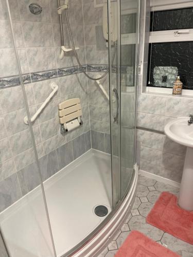 a shower with a glass door and a sink at King Edward house in Rhymney