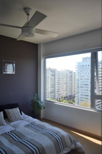 a bedroom with a bed and a large window at 2 ambientes con Amenities y Vista al Río in Vicente López