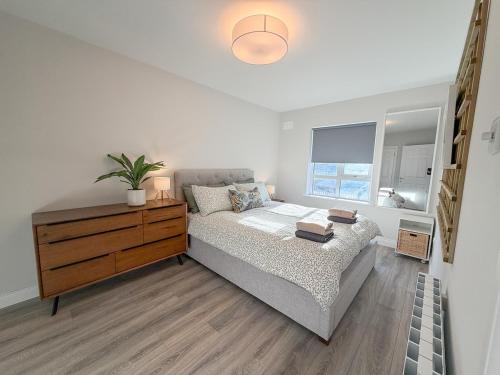 Un dormitorio con una cama y una cómoda y una ventana. en West Coast View 2 Bedroom Modern Apartment, en Bundoran