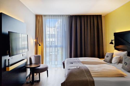 um quarto de hotel com uma cama e uma televisão em Holiday Inn - the niu, Fury Aschheim Messe by IHG em Aschheim