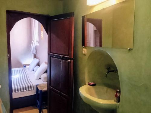 Un baño con lavabo, espejo y cama. en dar boumida, en Lalla Takerkoust