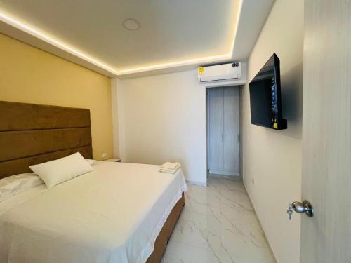 a bedroom with a bed and a flat screen tv at Penthouse Duplex Apartment en Cali, Ciudad 2000 in Cali