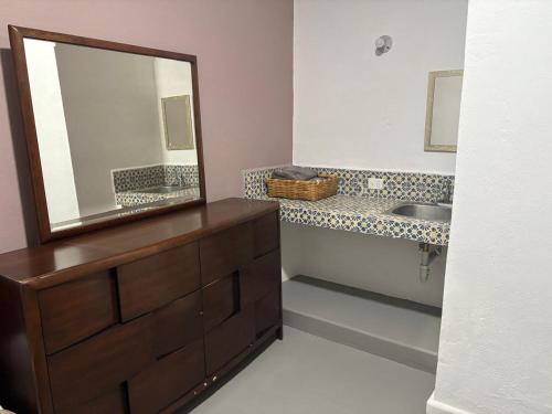 ein Badezimmer mit Waschbecken und Spiegel auf einer Kommode in der Unterkunft Casa Pila Seca in San Miguel de Allende