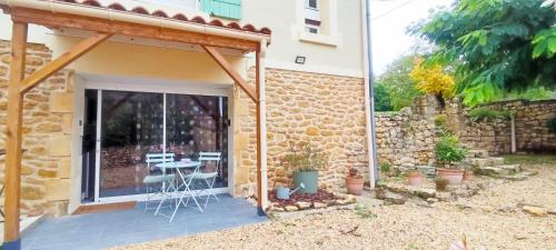 Cette maison en pierre dispose d'une terrasse et d'une table. dans l'établissement Studio Lindois, à Lalinde