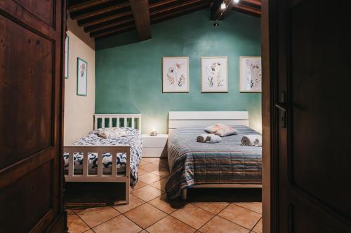 una camera da letto con due letti e una parete verde di La casa del Pucci a Lucca