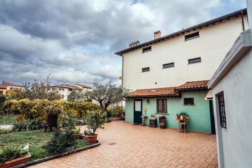 un grande edificio bianco con cortile con piante in vaso di La casa del Pucci a Lucca