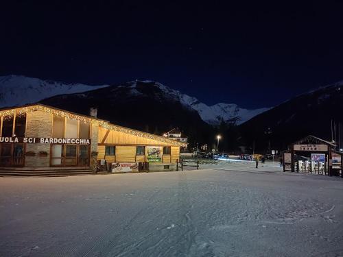 a building in the snow at night with a mountain at Appartamento panoramico in montagna Alpi Bardonecchia in Bardonecchia