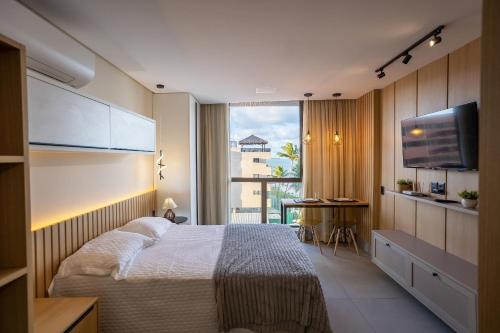 a hotel room with a bed and a large window at Get Sense #306 - Beira mar por Carpediem in Tambaú