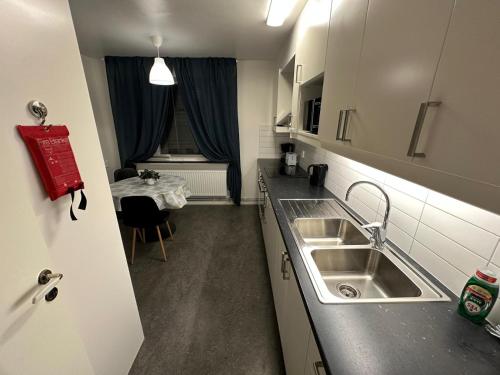 une petite cuisine avec un évier et une table dans l'établissement Noah longstay Kungsfågelgatan, à Västerås