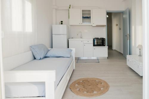 a white living room with a couch and a kitchen at Agapi in Xylokastro