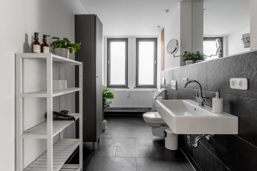 uma casa de banho em preto e branco com um lavatório e um WC em Global Living - Design Apartment I Rathausplatz I Kitchen I Augsburg em Augsburg