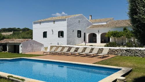 eine Villa mit einem Swimmingpool vor einem Haus in der Unterkunft Holiday Home Finca Binimazoch in Port d'Addaia