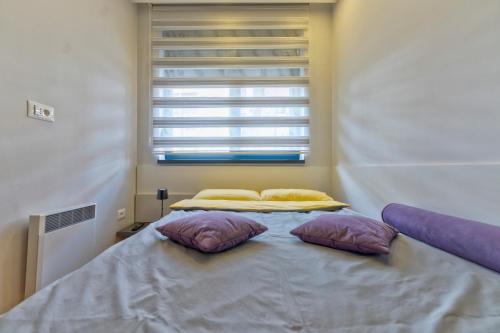 a bed in a room with two pillows on it at Jazz apartman Titova vila in Zlatibor