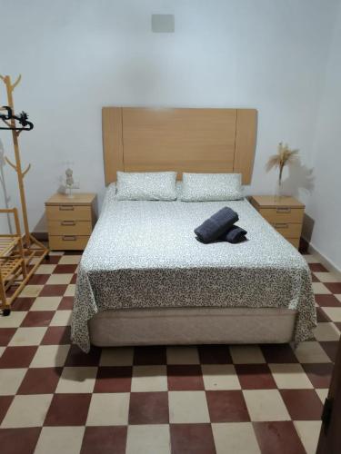 ein Schlafzimmer mit einem Bett und einem Schachbrettboden in der Unterkunft Casa el Castaño in Aracena