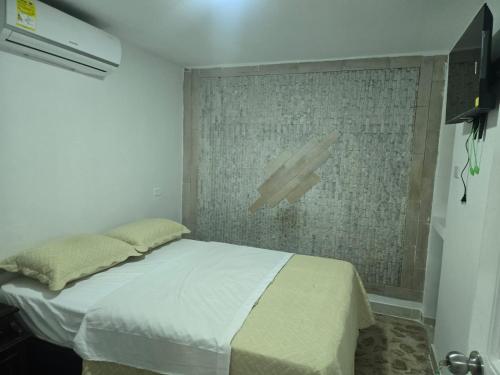a bedroom with a bed in a room with a wall at Hotel H&H in Cartagena de Indias