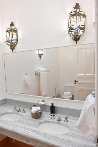 a bathroom with two sinks and a large mirror at Quinta das Águas by Summit Hotels in Itapira