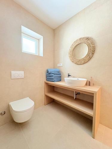 a bathroom with a toilet and a sink and a mirror at Villa Agava Mutogras in Podstrana