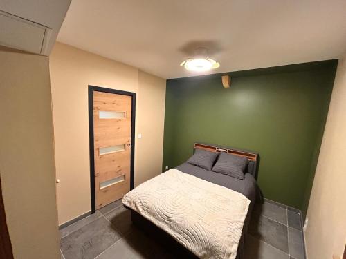 ein Schlafzimmer mit einem Bett und einer grünen Wand in der Unterkunft BullyCosy in Bully