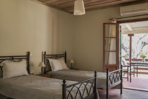 une chambre avec deux lits et un balcon dans l'établissement Lithies Organic Farm, à Vasilikos