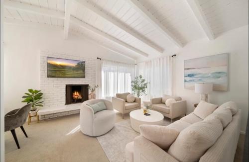 a living room with white furniture and a fireplace at Steps to Sand Cozy 3BR Partial Ocean Views in Manhattan Beach