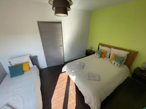 ein Schlafzimmer mit 2 Betten mit Kissen darauf in der Unterkunft Gîte La Bandsäge rando,rivière,quietude 