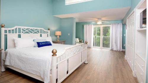 een slaapkamer met een wit bed en blauwe muren bij 701 Mariners Club in Key Largo