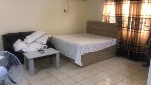 una pequeña habitación con una cama y una mesa en Noblelite Hotels, en Gwarinpa
