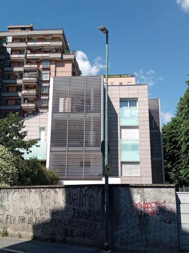 un bâtiment couvert de graffitis à côté d'un mur dans l'établissement A casa di ANDREA - 25 MINUTI DAL DUOMO, à Sesto San Giovanni