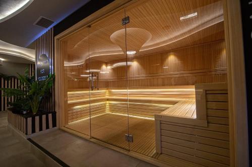 a sauna with a glass door in a building at Jazz apartman Titova vila in Zlatibor