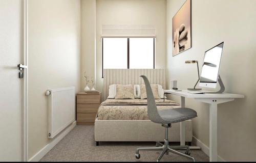 ein Schlafzimmer mit einem Bett und einem Schreibtisch mit einem Computer in der Unterkunft Luxurious Bedroom and Living room in a House in Romford