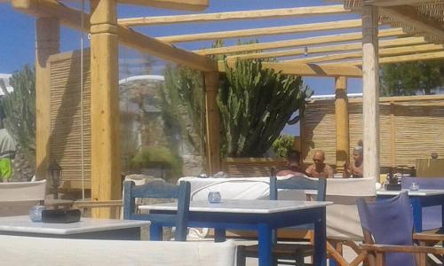 a painting of a patio with tables and a fountain at Peristeronas Village in Klouvas