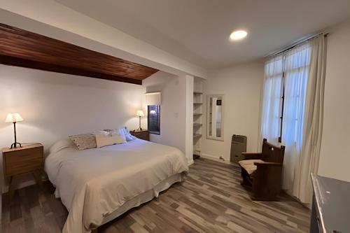 a bedroom with a large bed and a window at CosmoSur - Centro El Bolson in El Bolsón