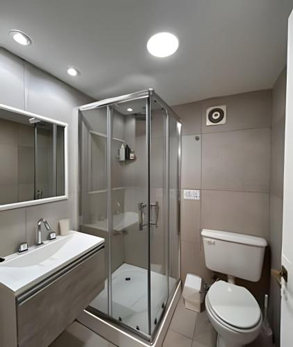 a bathroom with a shower and a toilet and a sink at CosmoSur - Centro El Bolson in El Bolsón
