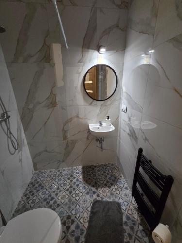 a bathroom with a sink and a toilet and a mirror at Hotel Sarai Wrocław in Wrocław