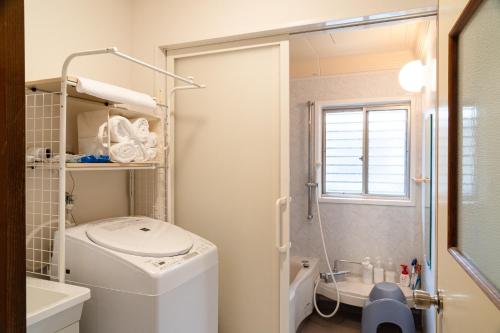 ein Badezimmer mit Waschmaschine und Dusche in der Unterkunft Guesthouse HIKETA Secret Base - Vacation STAY 92223v in Higashikagawa