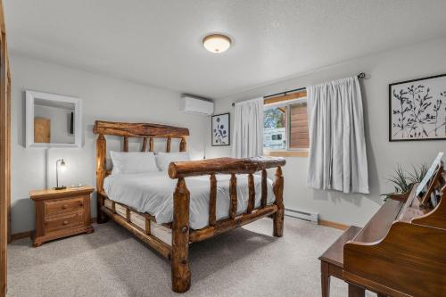 ein Schlafzimmer mit einem Holzbett und einem Klavier in der Unterkunft Diamond in Deschutes River Woods