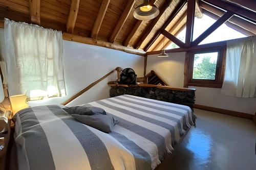 ein Schlafzimmer mit einem Bett in einem Zimmer mit einem Fenster in der Unterkunft Los Retoños in El Bolsón