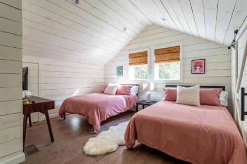 Dos camas en una habitación con paredes blancas. en Hare & Hollow with Hot Tub & Fenced Yard, en Long Eddy