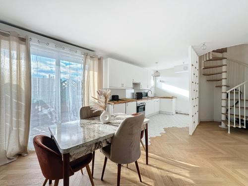 Apt 6p-Standing RER Paris 15 min في جوافيل: مطبخ وغرفة طعام مع طاولة وكراسي