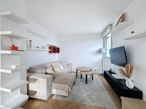 Apt 6p-Standing RER Paris 15 min في جوافيل: غرفة معيشة بيضاء مع أريكة وتلفزيون