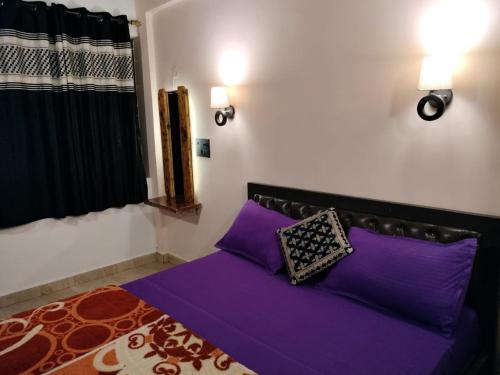 a purple bed with two pillows in a bedroom at Carolina Deluxe GuestHouse Wi-Fi in Colva