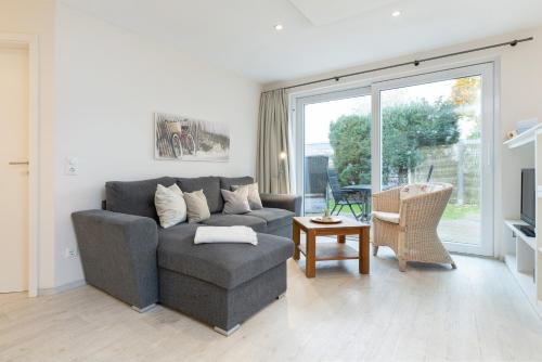a living room with a couch and a table at D4 Bungalow - Haus Dünenpark Königsberger Allee 12 - FERIENDOMIZIL HOLLICH in Grömitz